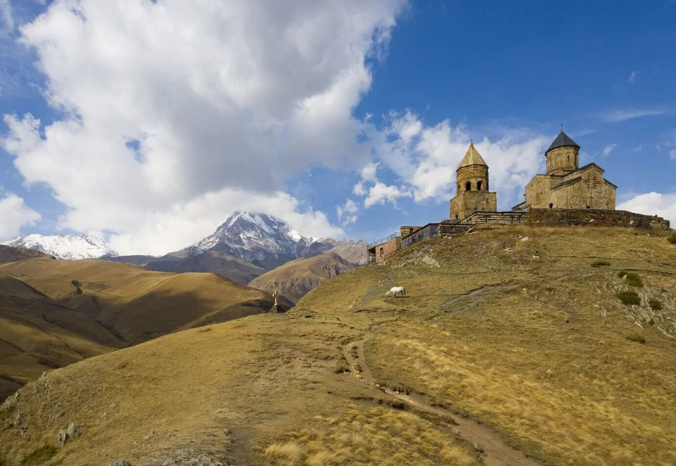 Wunderschöne Ansicht der Gergeti-Dreifaltigkeitskirche, aufgenommen unter bewölktem Himmel in Georgien.